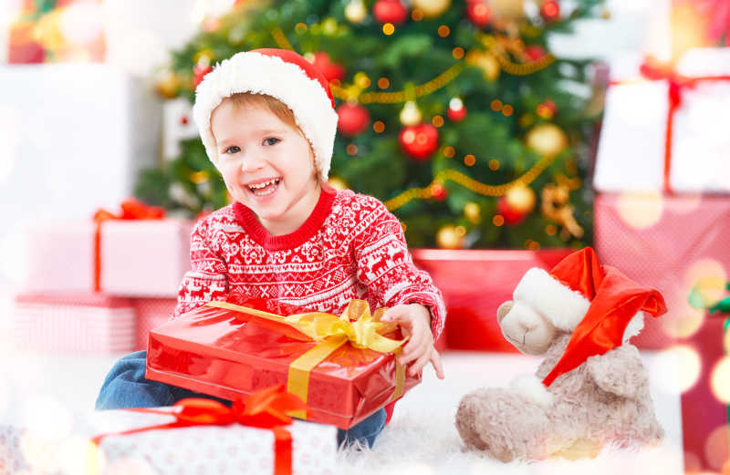圣诞树旁有圣诞礼物的和快乐的孩子