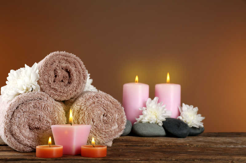 木质桌子上的沐浴毛巾卵石和蜡烛