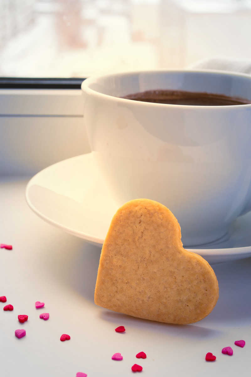 窗户前的一杯热咖啡与饼干