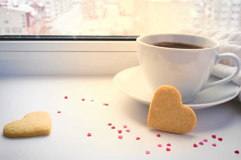 百叶窗前的咖啡与两个心形饼干