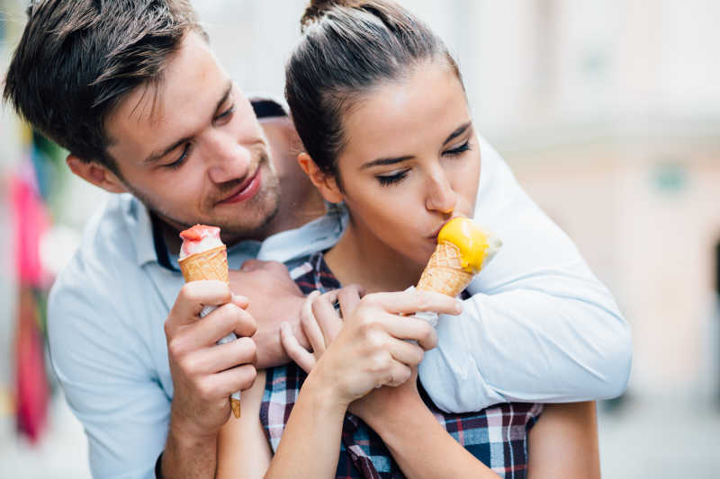 在大街上拥抱着吃冰淇淋的情侣