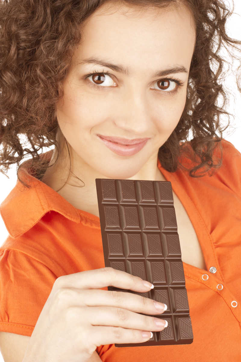 白色背景下拿着巧克力的美丽女孩