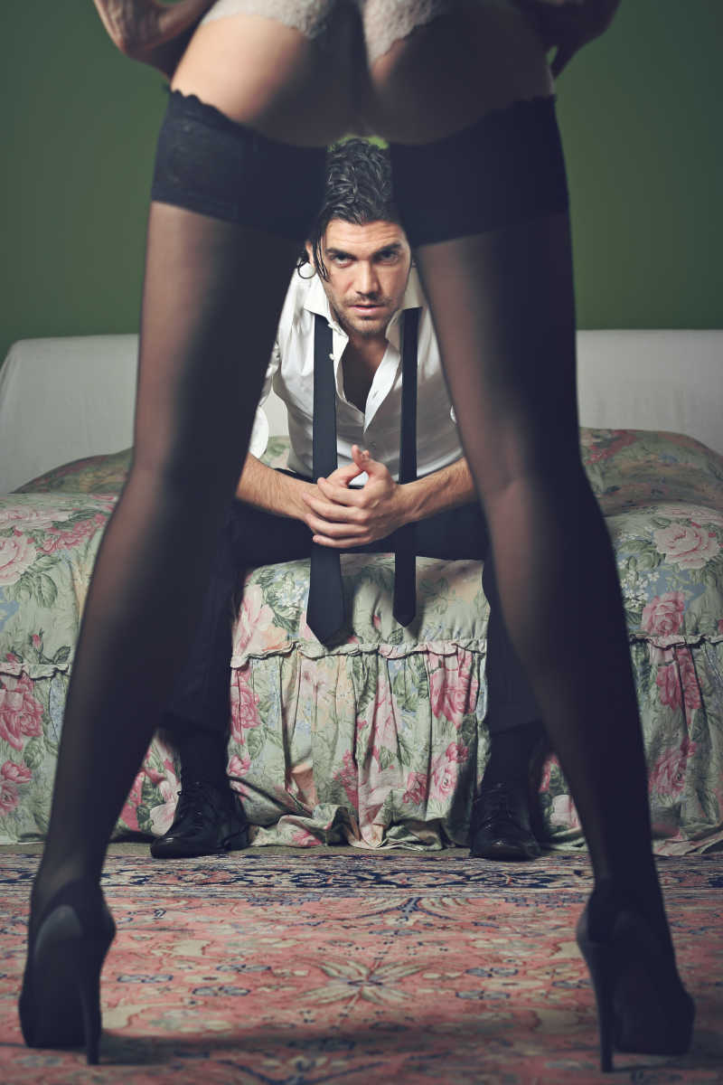坐在床上的男士和性感女人的大长腿