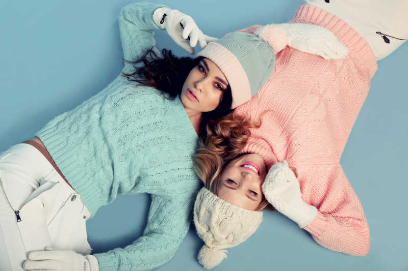 两个年轻女孩穿着舒适温暖的针织衣服