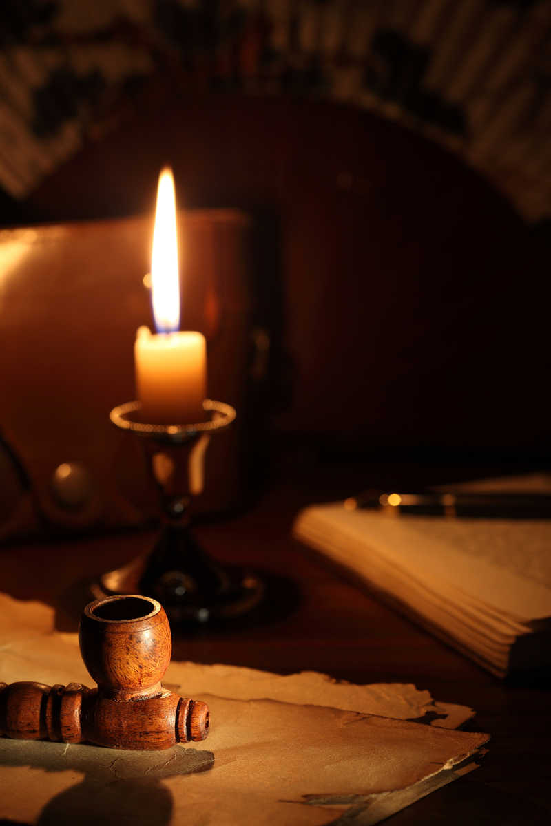 陈旧的书桌上点燃的蜡烛