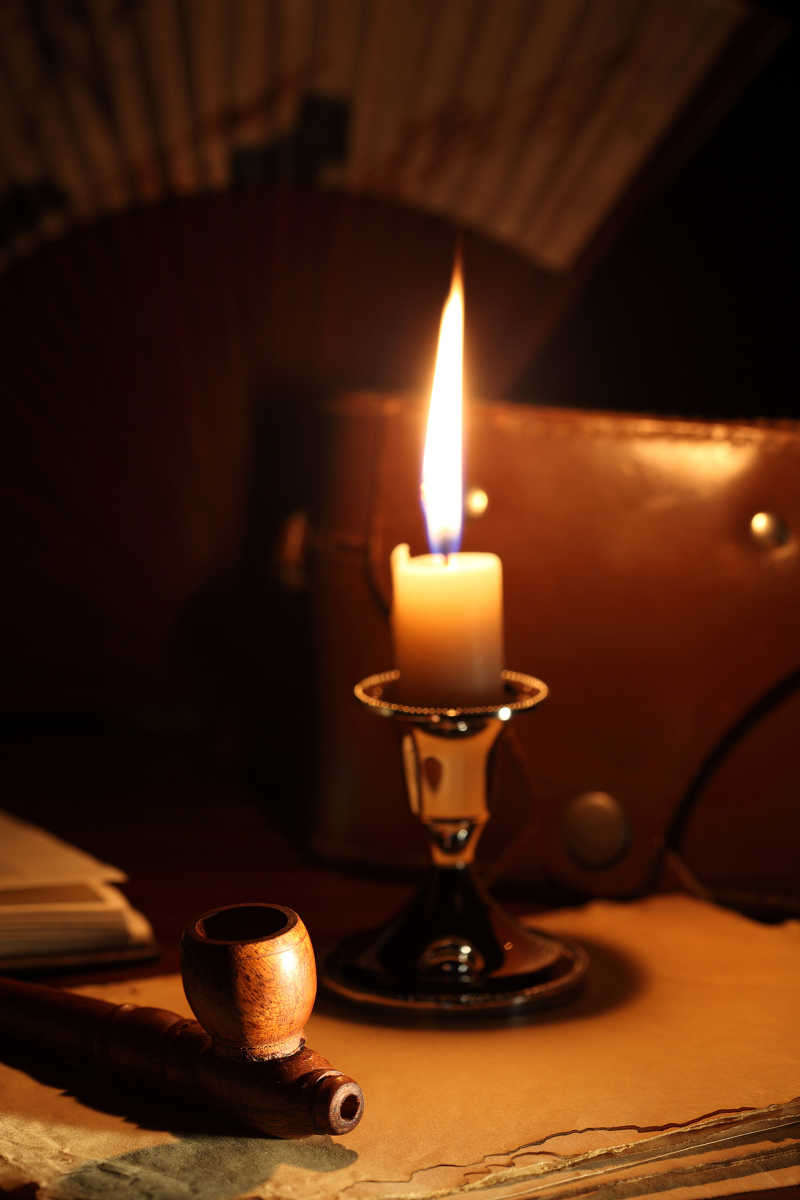 书桌上摆放的书籍和蜡烛