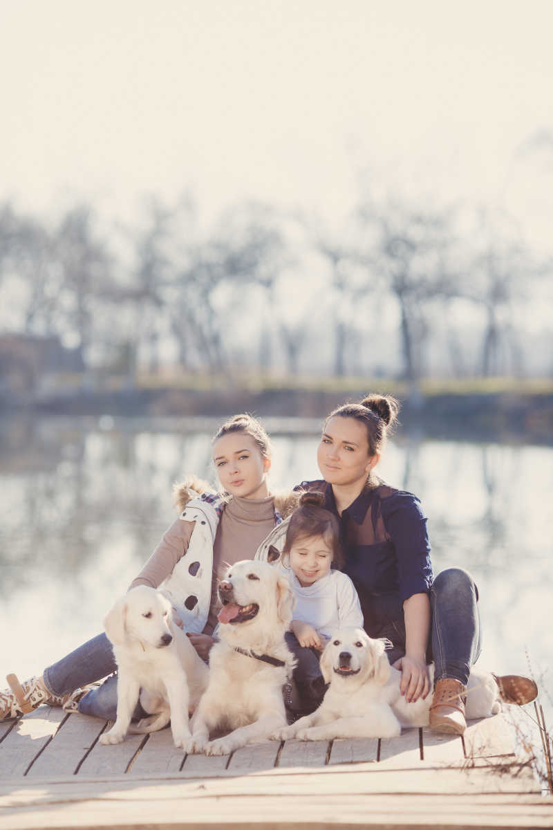 秋季公园里带着狗狗度假的幸福家庭