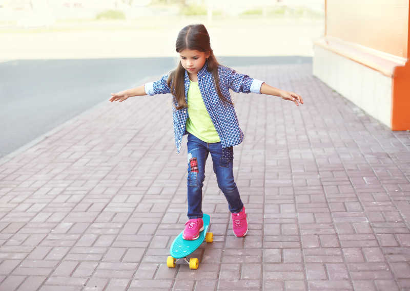小女孩骑在滑板上