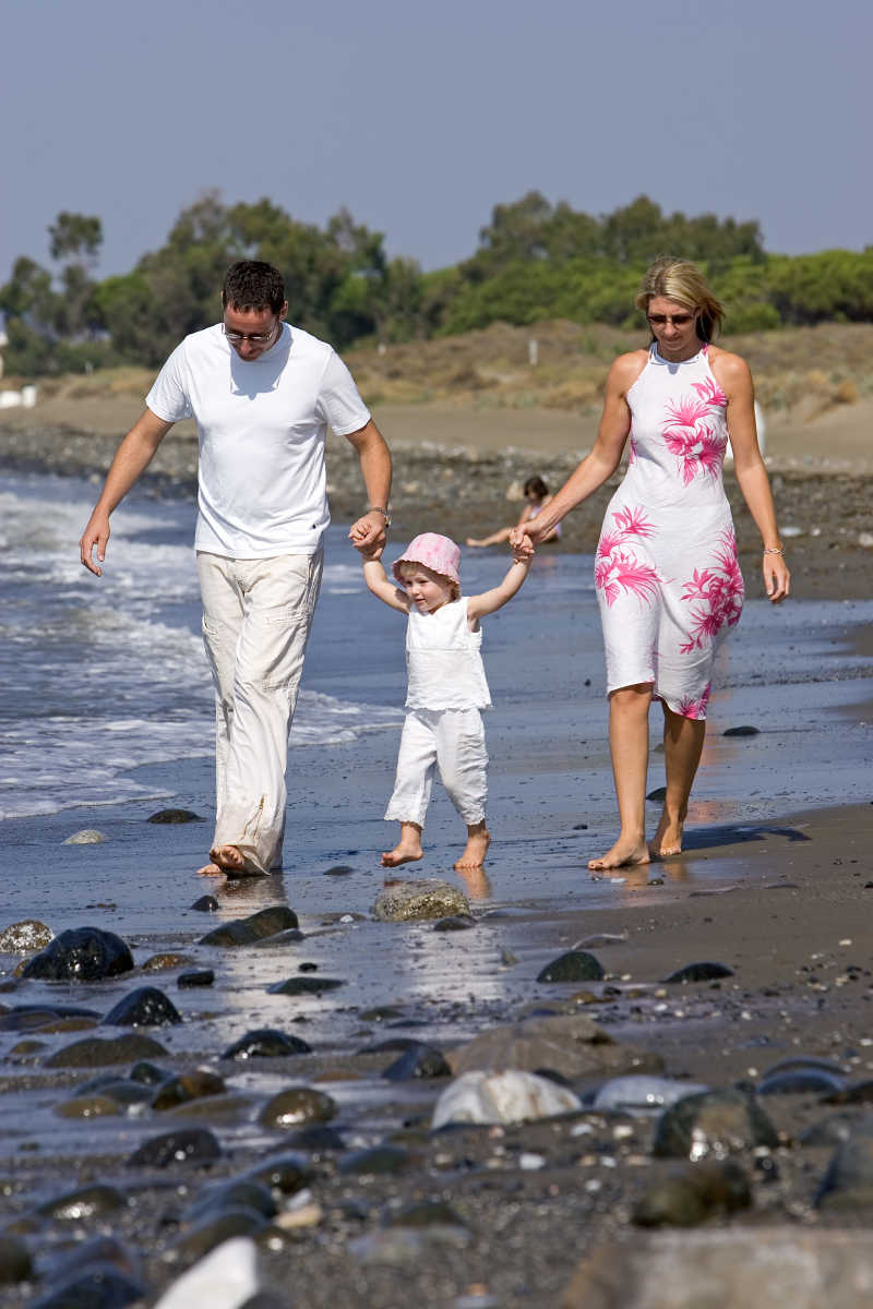 阳光明媚的海滩上年轻健康的一家人