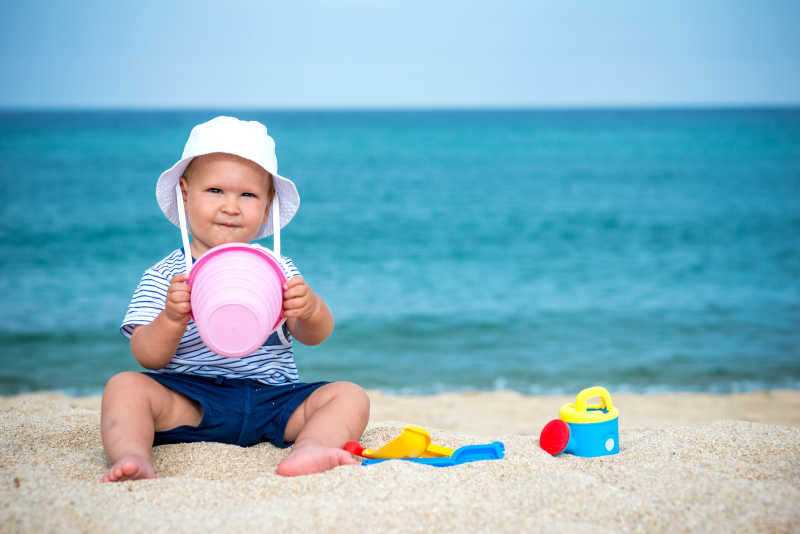 在沙滩上玩沙子的小男孩