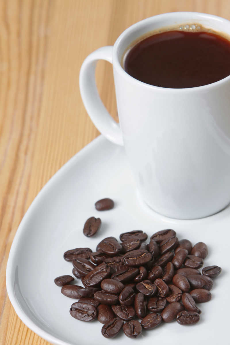 白色咖啡杯里的咖啡与咖啡豆