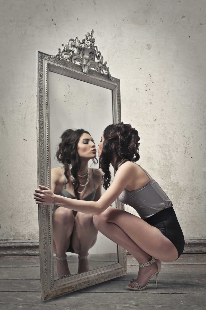 蹲在镜子前面的可爱女子