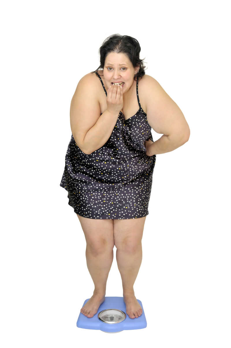 肥胖的女人在测量体重