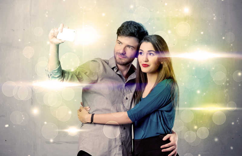 一个新的幸福的夫妇采取selfie的照片在彩灯闪烁背景前自拍