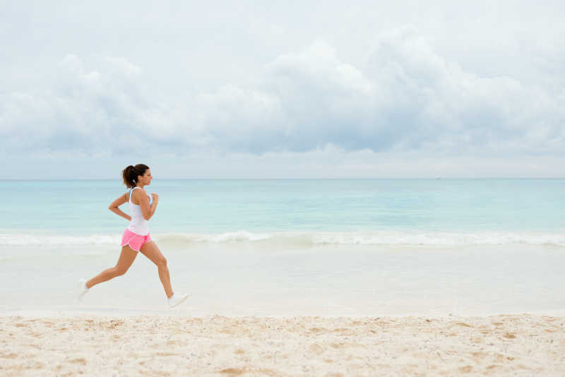 在海滩上跑步的健康女孩