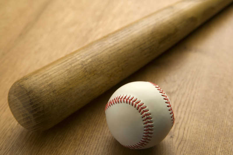 木地板上的老式棒球球棒和棒球