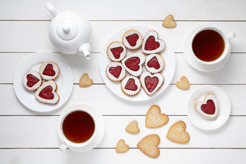 木板上由心形饼干和红茶组成的情人节早餐