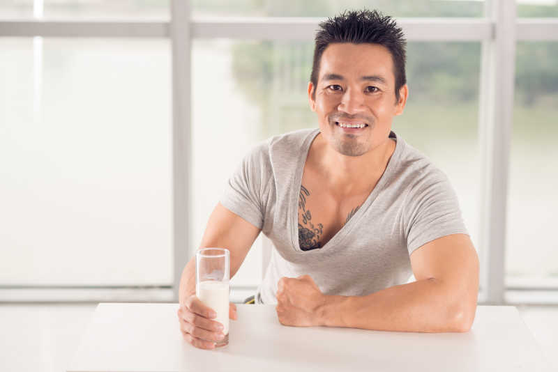 身材健硕的中年男性手里拿着一杯牛奶