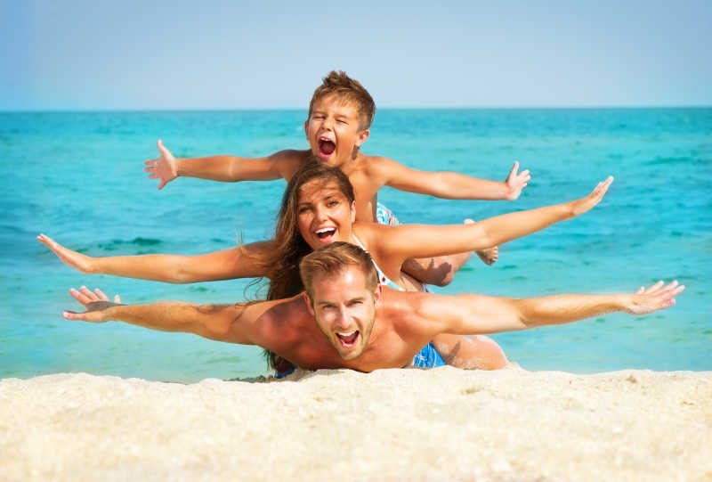 一家人在沙滩上做飞翔的动作