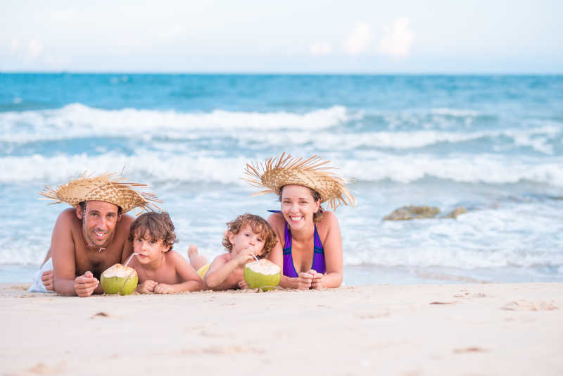一家人趴在海边的沙滩上