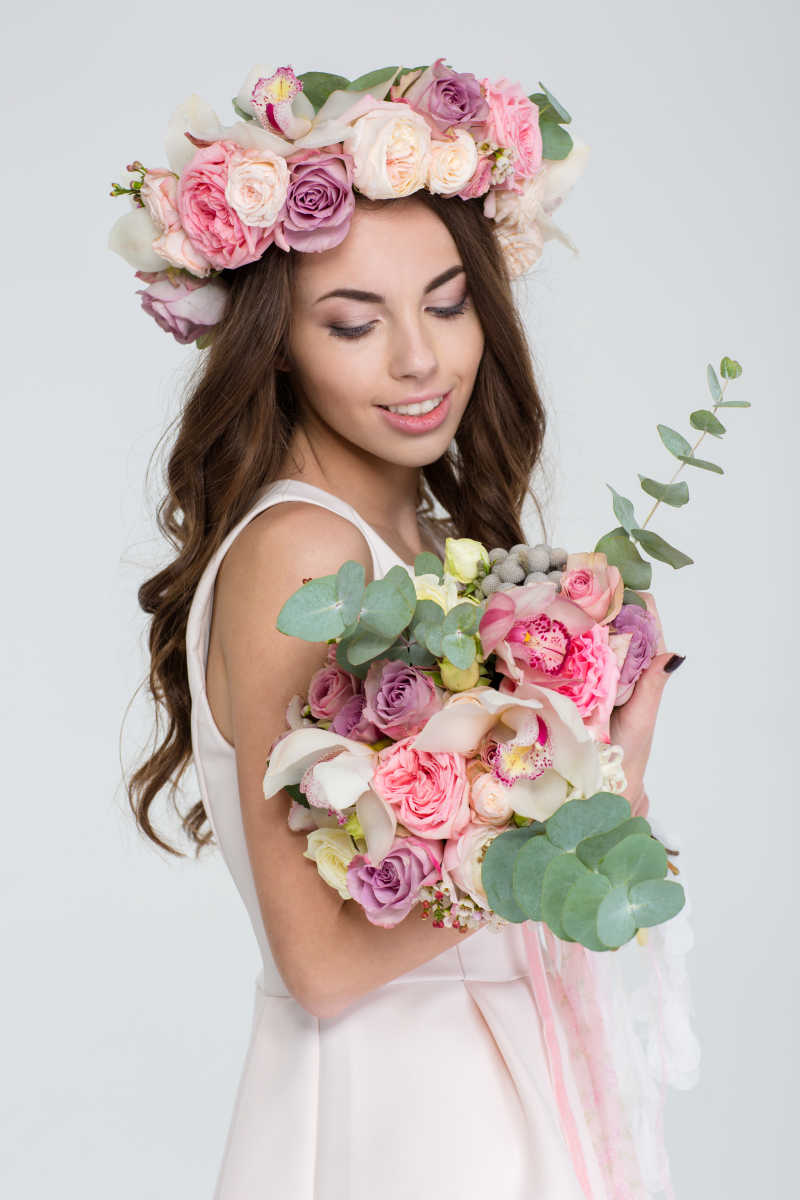 迷人的年轻新娘抱着花束