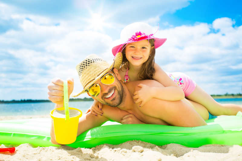 父亲和女儿在海滩上一起玩