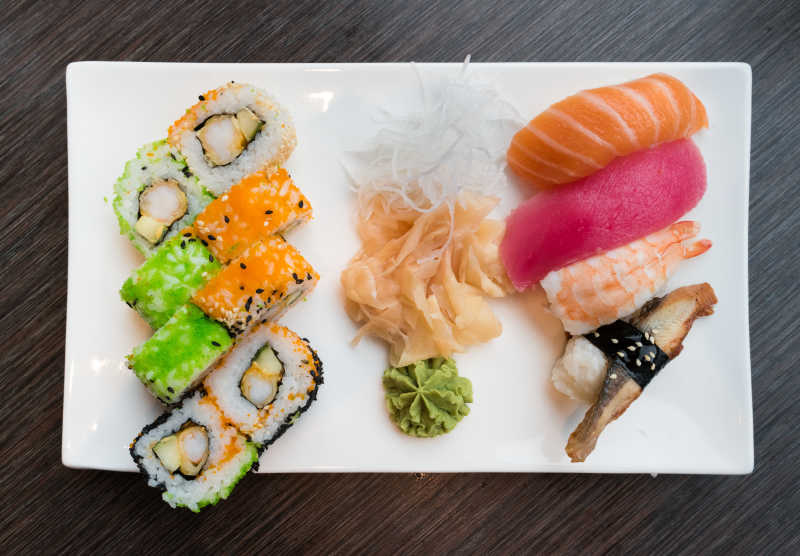 白色盘子里的生鱼片寿司和粟实卷