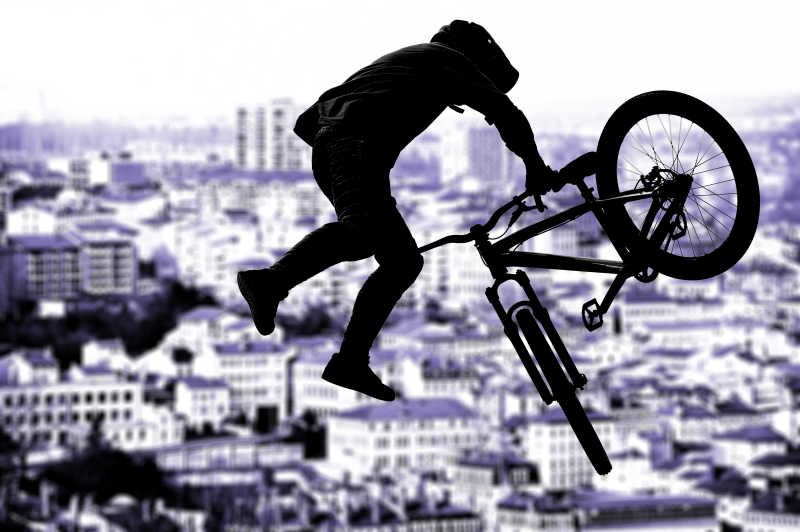 小轮车运动的骑手在风景的背景上的动作剪影