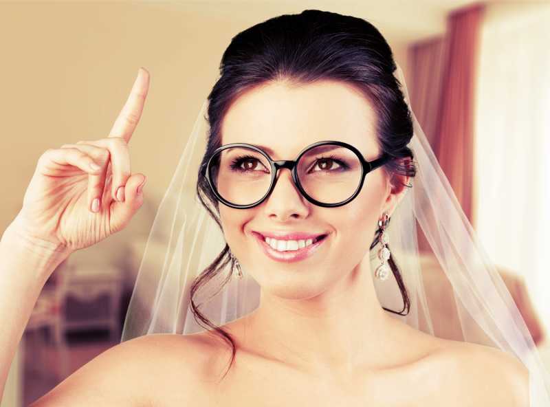 穿着婚纱戴着眼镜的幸福的新娘
