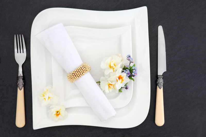 深色桌面上的餐盘餐具和餐巾