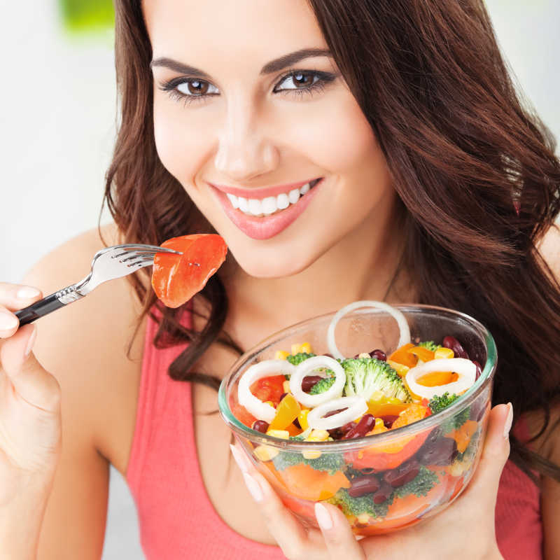 黑发女人正在吃素食蔬菜沙拉
