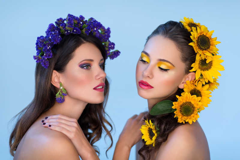 头发上有黄色和紫色的花朵的两位美女