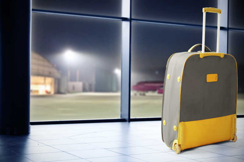 夜晚中的机场中的手提箱概念