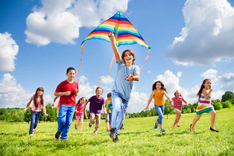 一群快乐的孩子在草地上放风筝