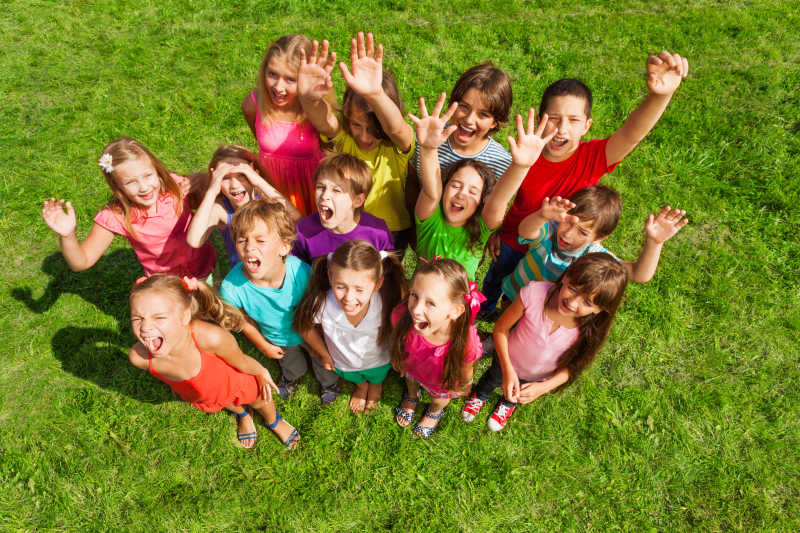 一群快乐的孩子站在绿色的草坪上