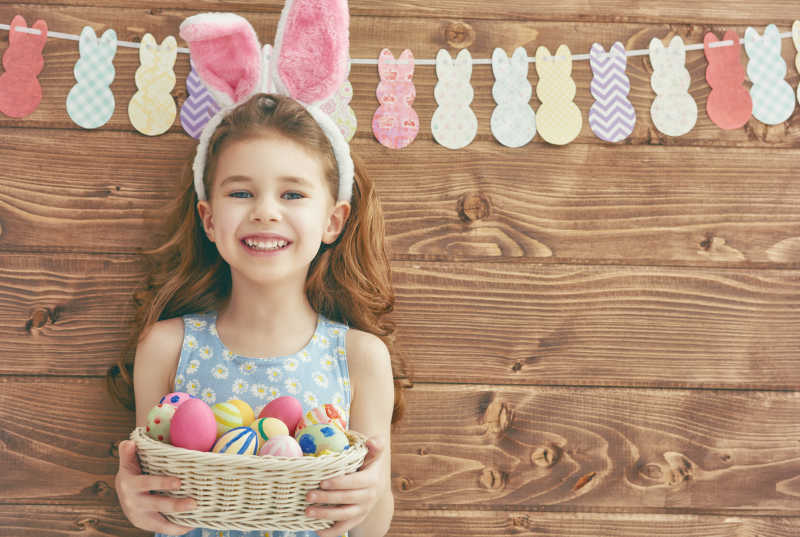 戴着兔耳朵发箍抱着彩蛋的小女孩