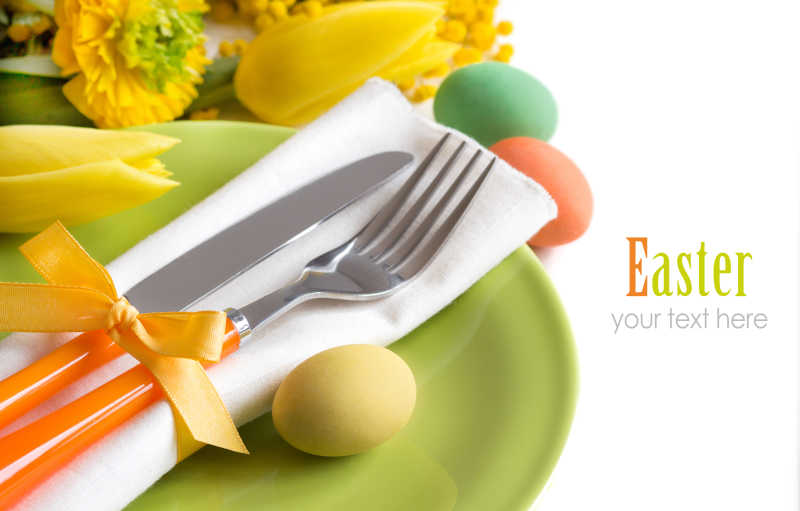 白色背景下的黄色花朵和复活节餐具彩蛋