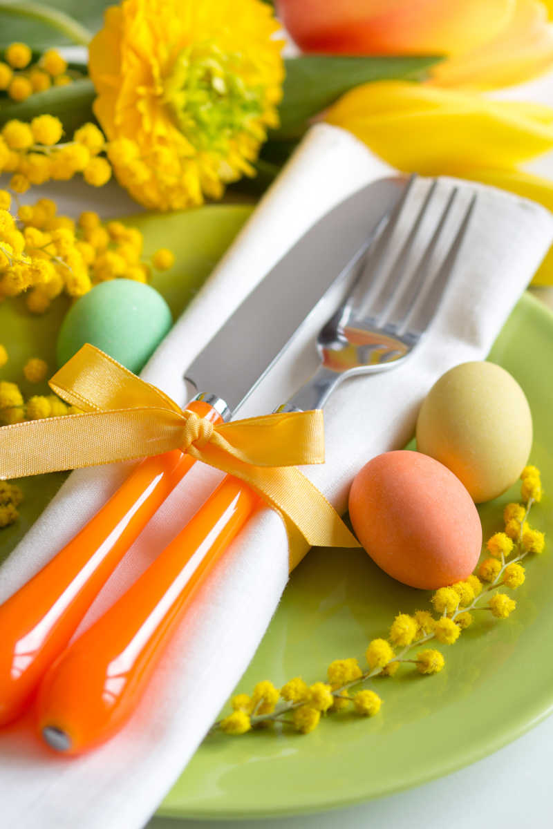 郁金香背景下的餐具和彩蛋