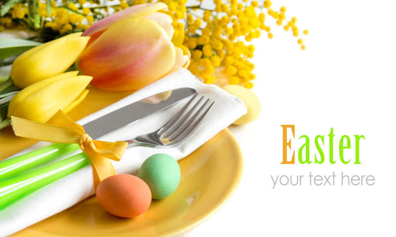 白色背景下复活节餐桌上的郁金香和彩蛋