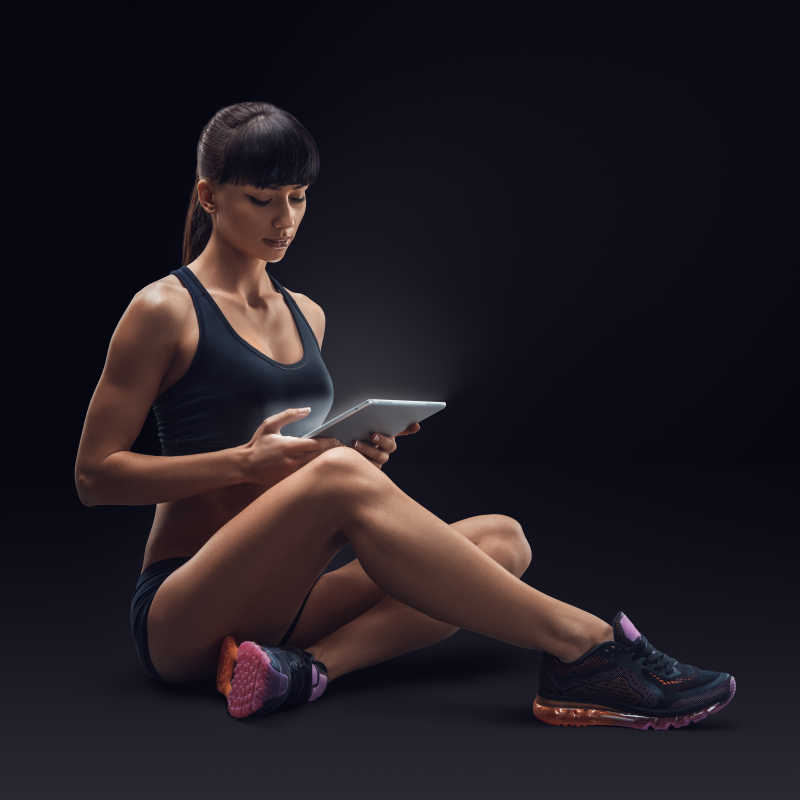 健身的女子看着平板电脑