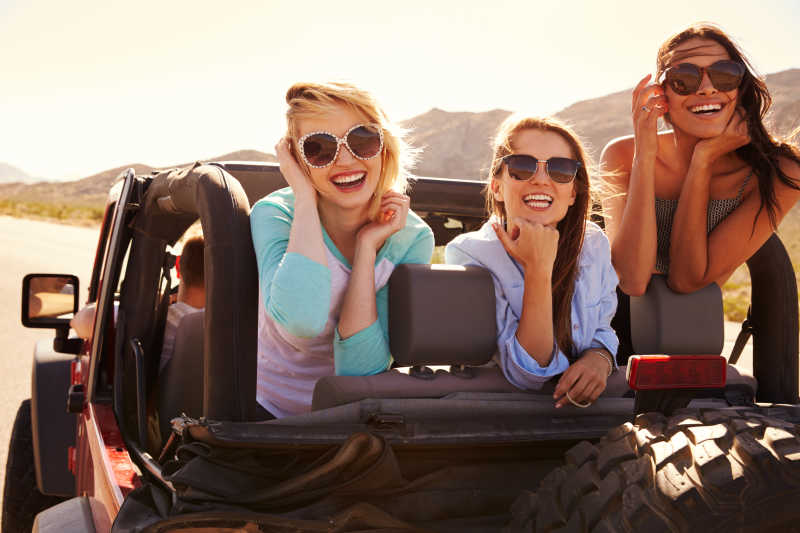 三个女性朋友在敞篷车的车上旅行