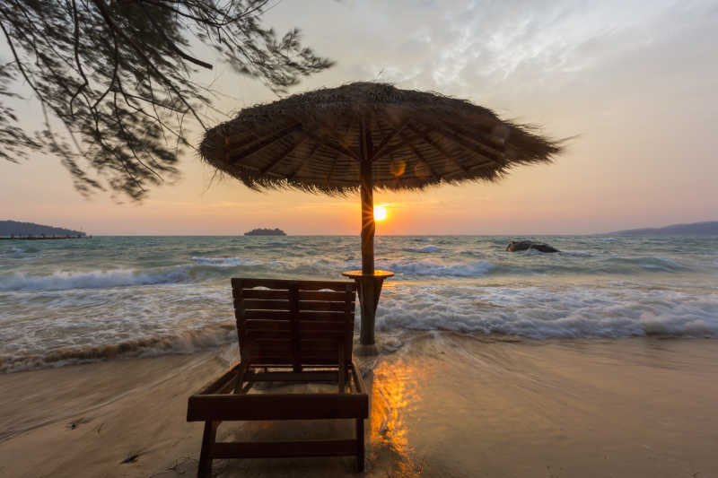 柬埔寨高龙日出时带着麦秆伞的空海滩