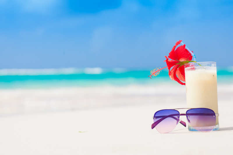新鲜的冰镇果汁朗姆酒和太阳镜的热带海滩上