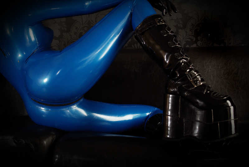 躺在地板上穿着蓝色重型橡胶黑色皮靴的女人