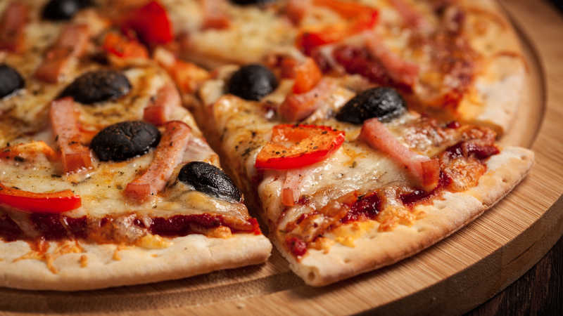 木板上美味的火腿披萨
