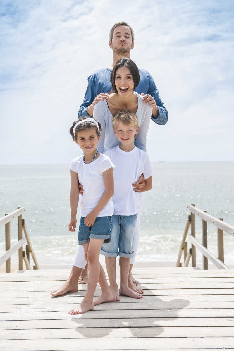 站在海边的木浮桥上的幸福家庭