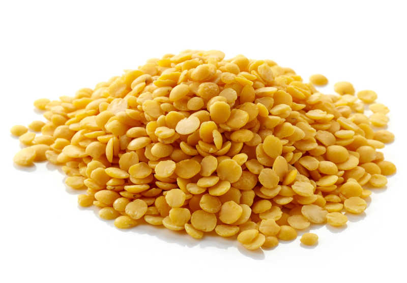 白色背景下的黄色印度扁豆堆