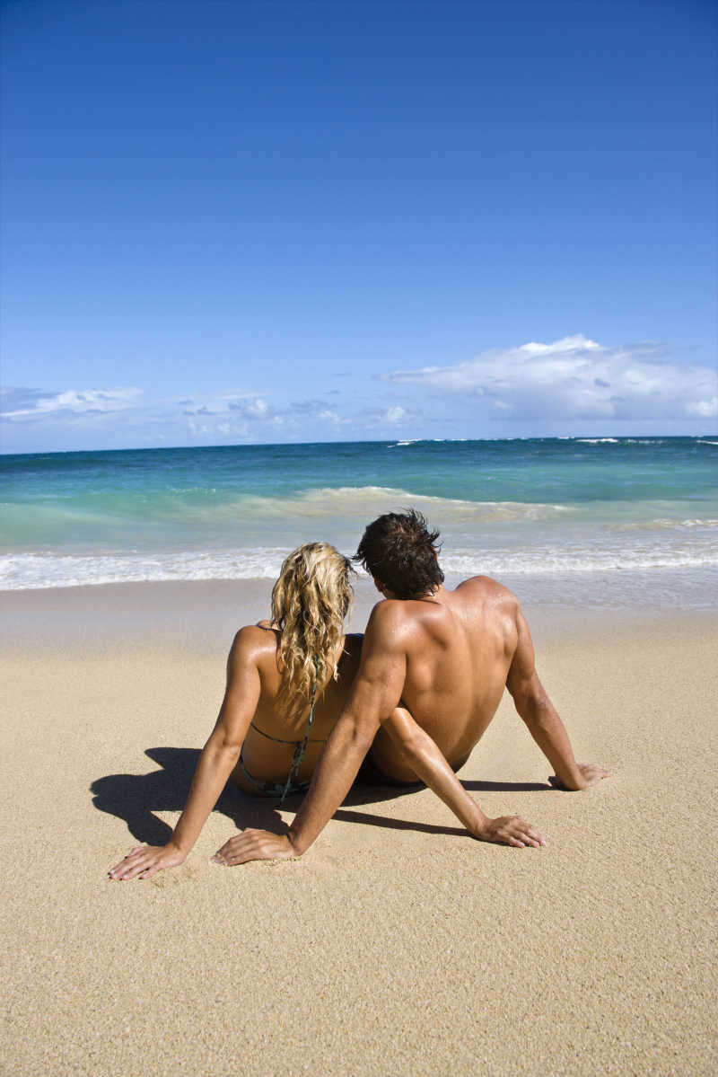 海滩上年轻情侣的背影
