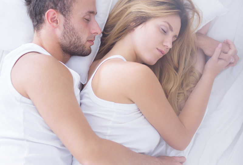 年轻夫妇睡在床上拥抱