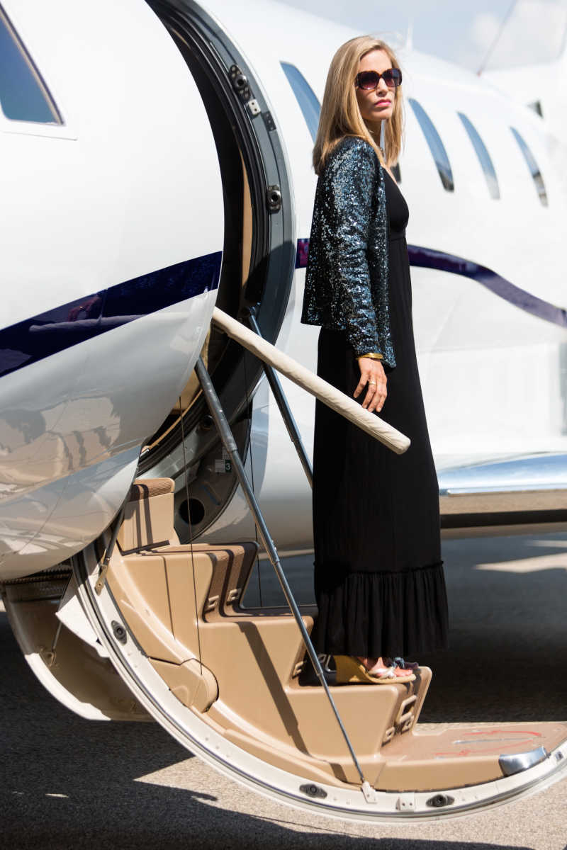 走出私人飞机的时尚女人